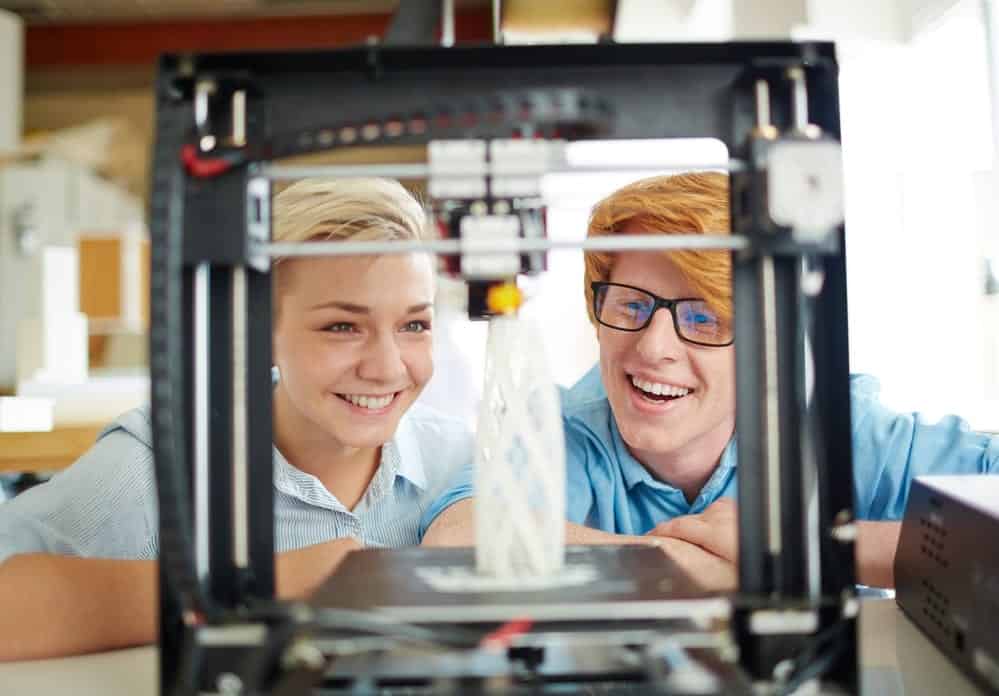 Ingenieros mirando el modelo en la impresora 3d