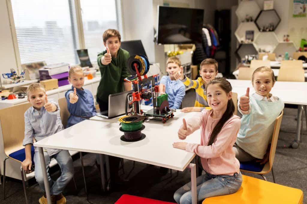Ninos felices con impresora 3d en la escuela de robotica