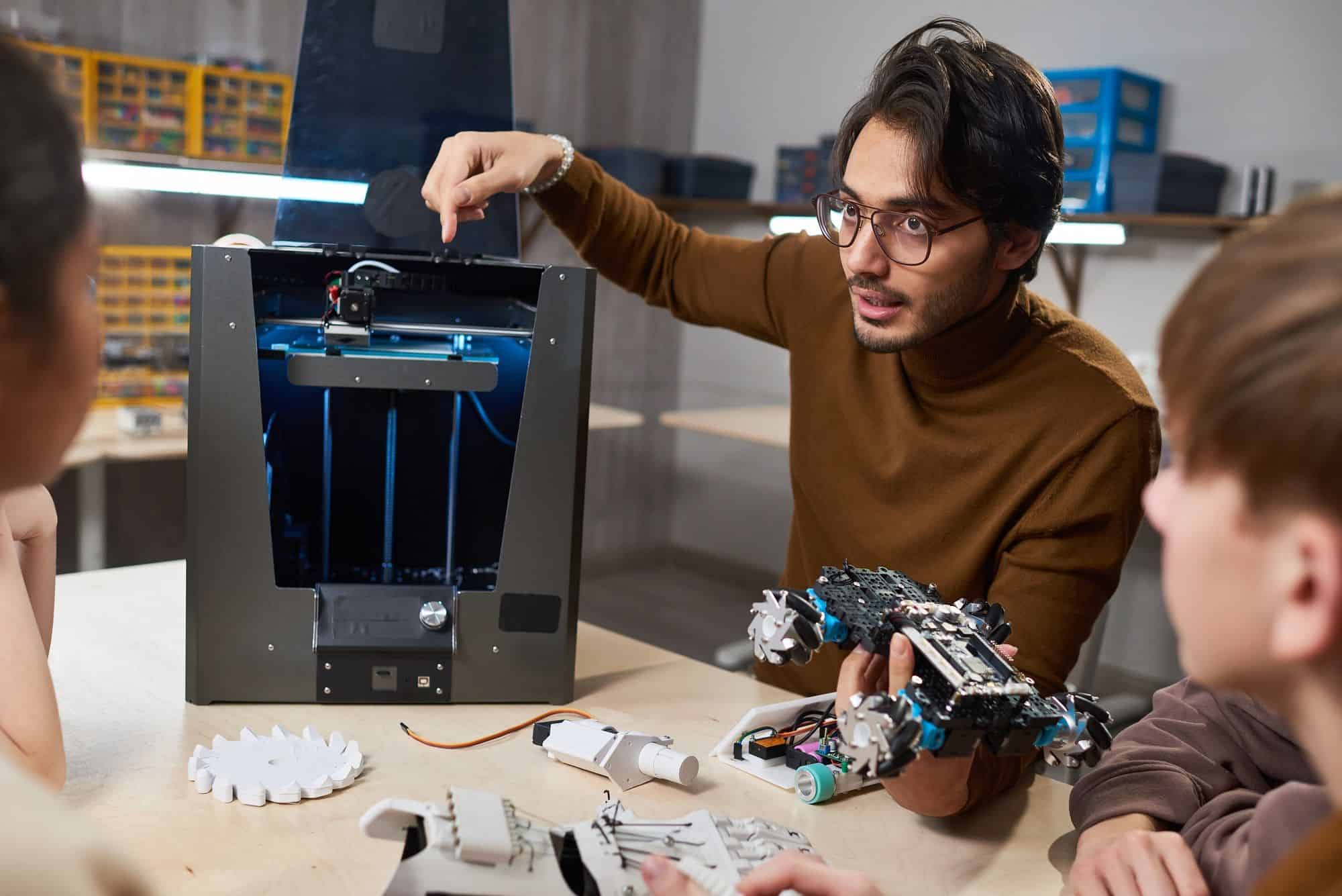 Profesor que demuestra la impresora 3D a la clase